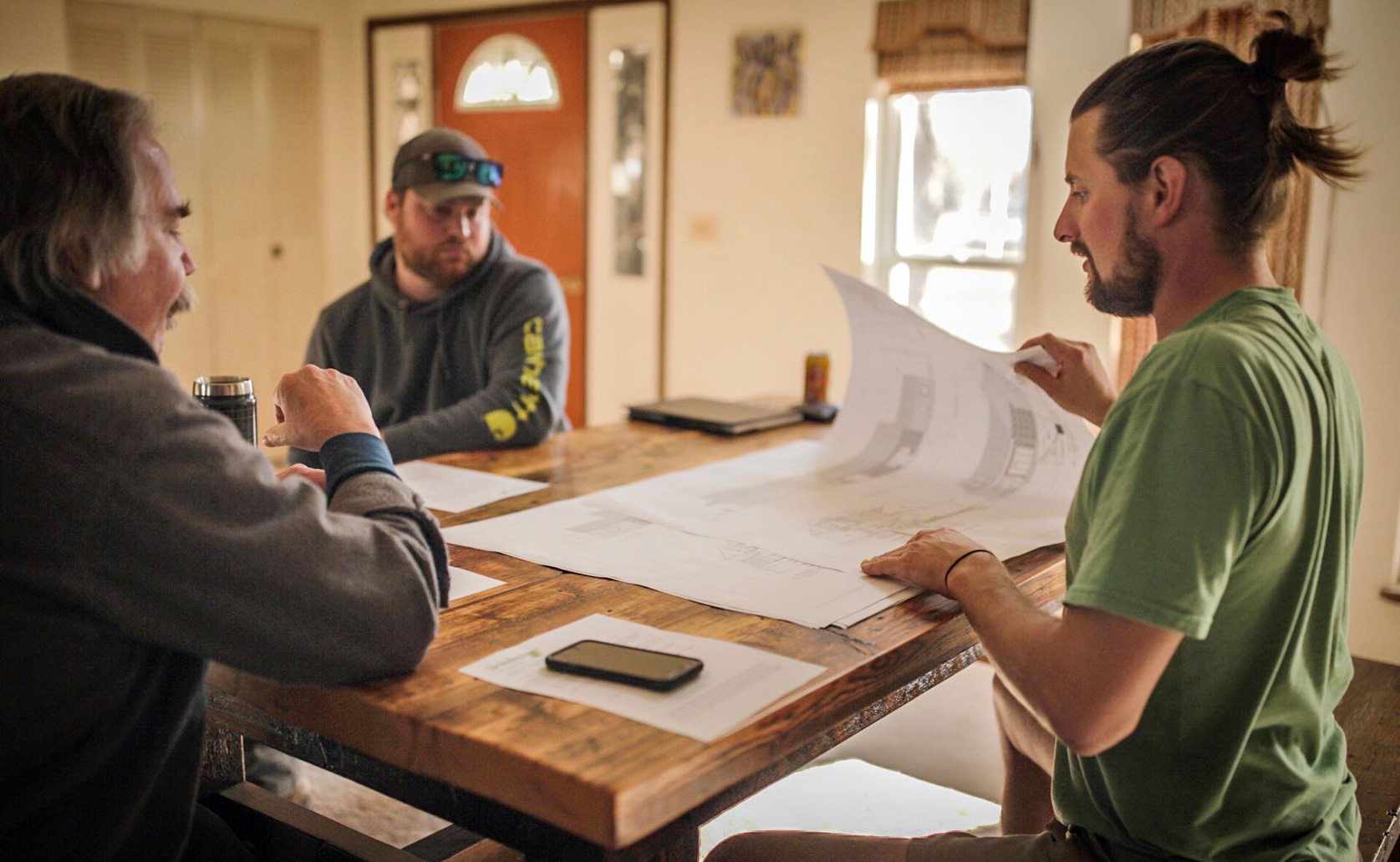 Jon and associates review plans for upcoming project.